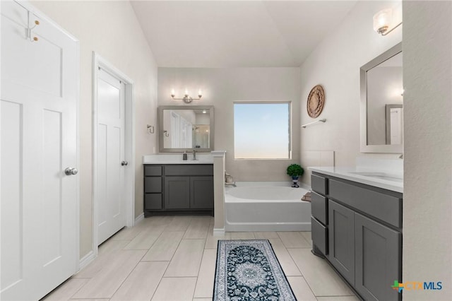 bathroom featuring vanity, a bath, and tile patterned floors