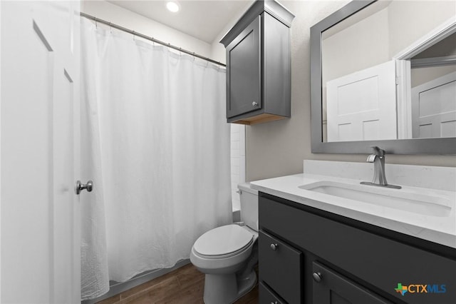 bathroom with vanity, toilet, curtained shower, and hardwood / wood-style floors