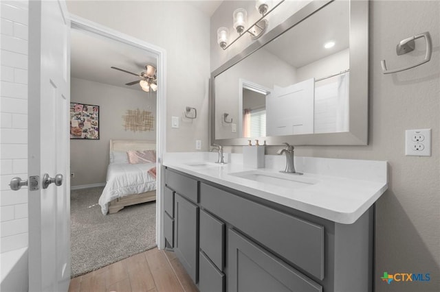 bathroom with walk in shower, ceiling fan, and vanity