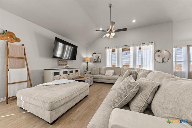 living room featuring vaulted ceiling, light hardwood / wood-style floors, and ceiling fan