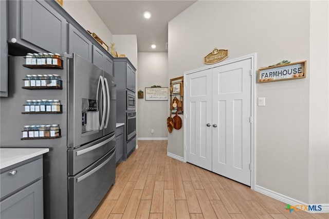 kitchen with stainless steel appliances, light wood-type flooring, and gray cabinetry