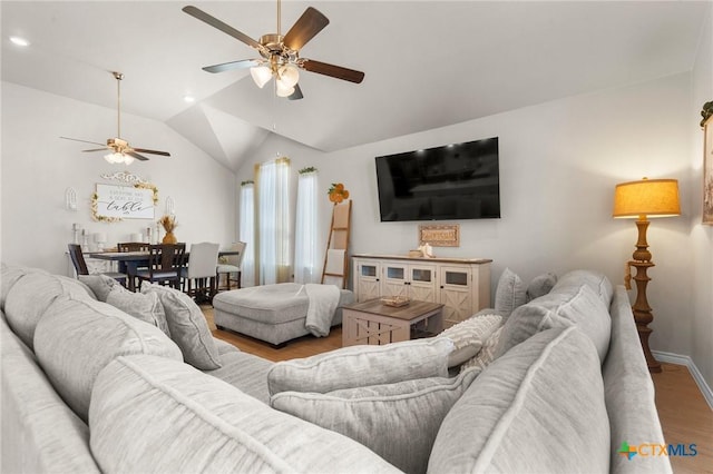 living room with vaulted ceiling, light hardwood / wood-style floors, and ceiling fan