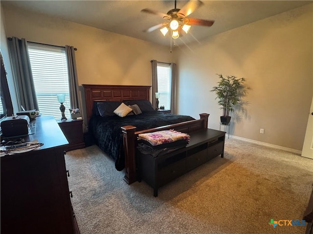 bedroom featuring light colored carpet, ceiling fan, and baseboards