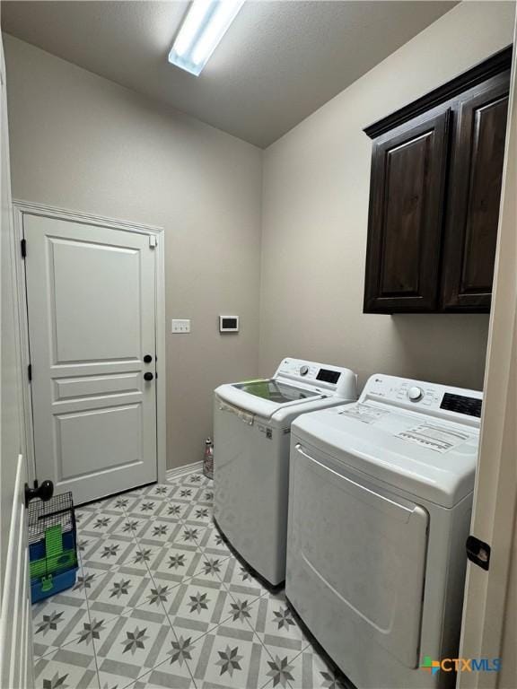 laundry area featuring cabinet space, washer and clothes dryer, and light floors