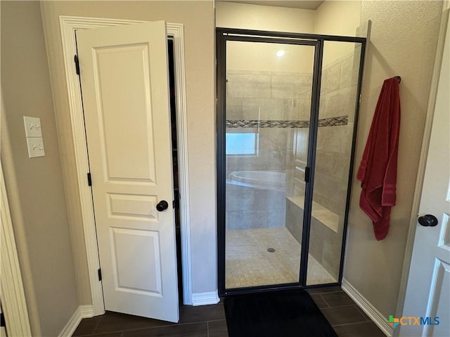 bathroom with a stall shower and baseboards