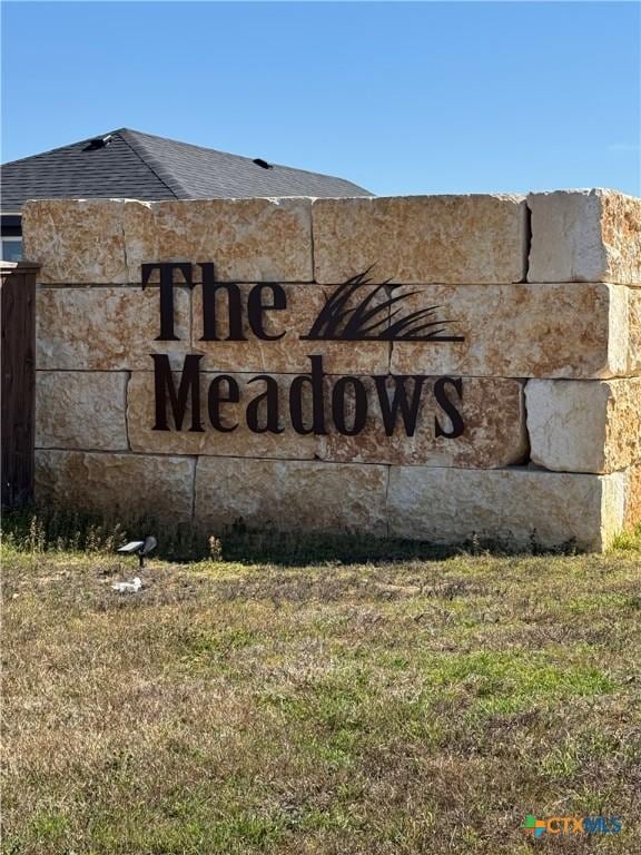 community / neighborhood sign featuring a lawn