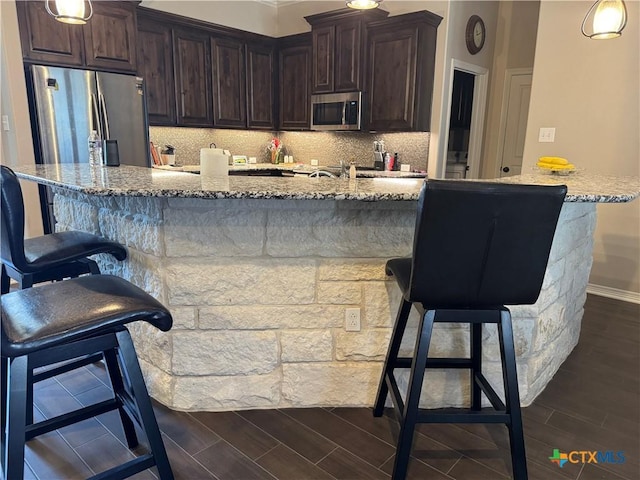 kitchen with wood tiled floor, stainless steel appliances, and decorative backsplash