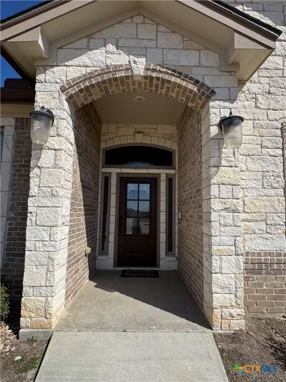 doorway to property featuring brick siding