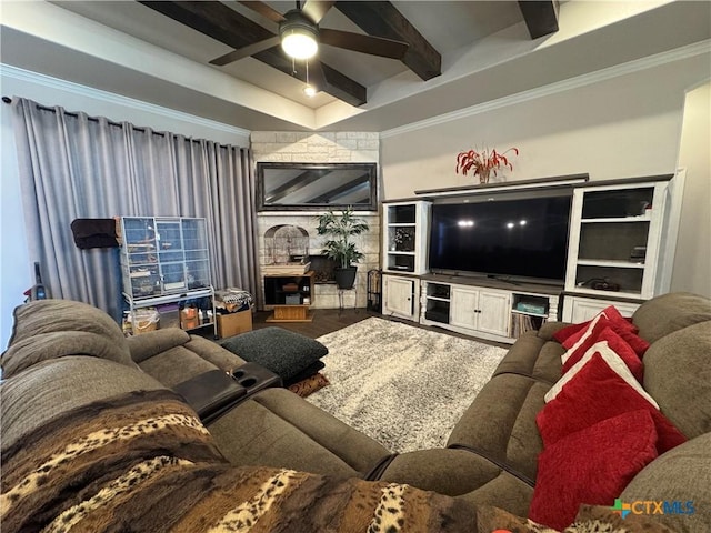 living area with ornamental molding, a ceiling fan, beamed ceiling, and wood finished floors