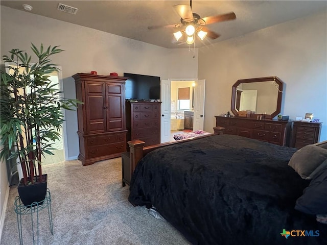 bedroom with light carpet, ceiling fan, visible vents, and ensuite bathroom