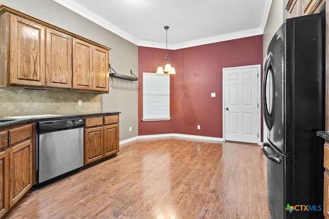 kitchen featuring black fridge, wood-type flooring, backsplash, and stainless steel dishwasher