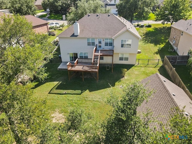 back of house featuring a lawn and a wooden deck