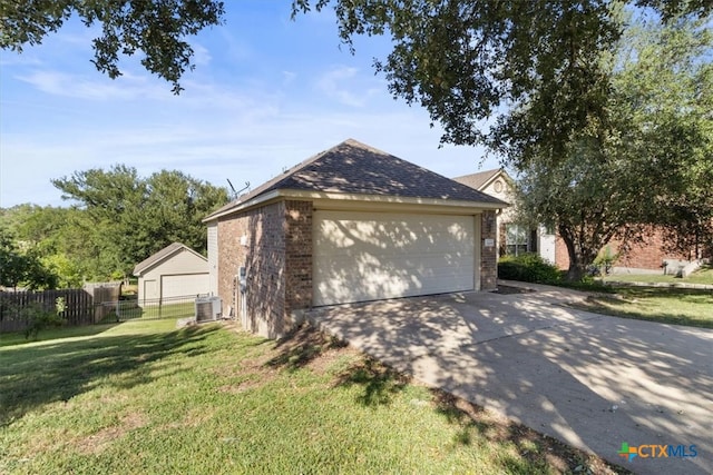 view of home's exterior with an outbuilding, central air condition unit, a garage, and a yard