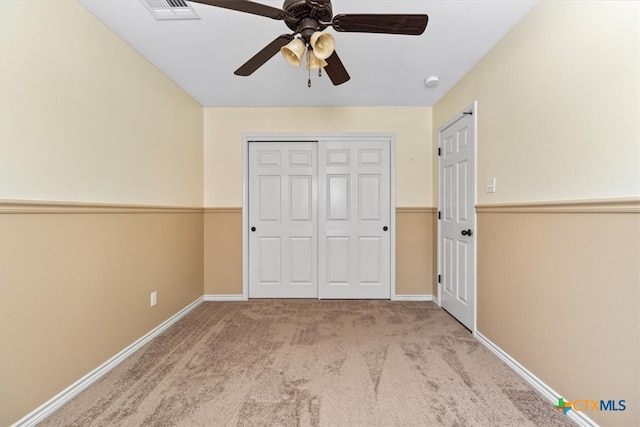 unfurnished bedroom with ceiling fan and light colored carpet