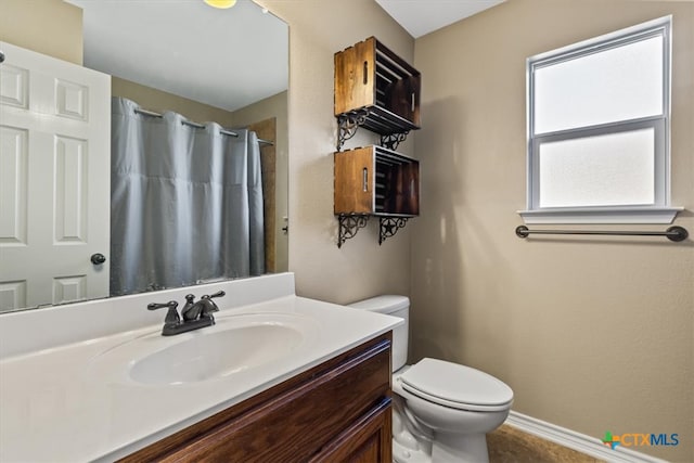 bathroom with toilet, vanity, and a shower with shower curtain