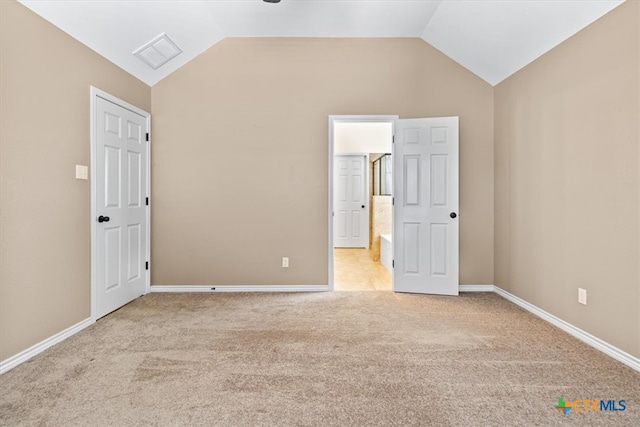 interior space featuring light colored carpet and vaulted ceiling