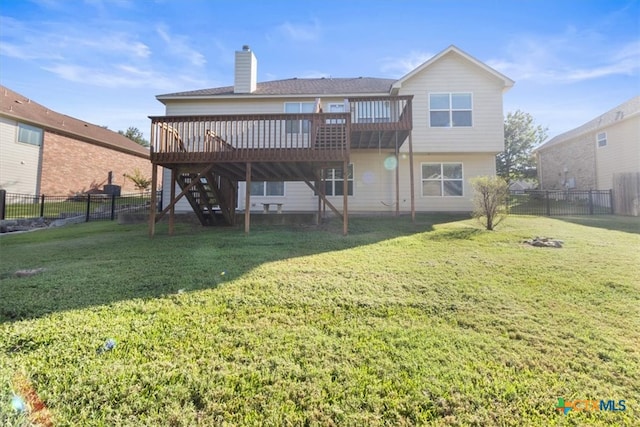 rear view of house featuring a deck and a yard