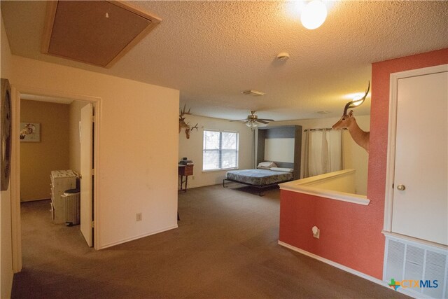 hall featuring a textured ceiling and carpet flooring