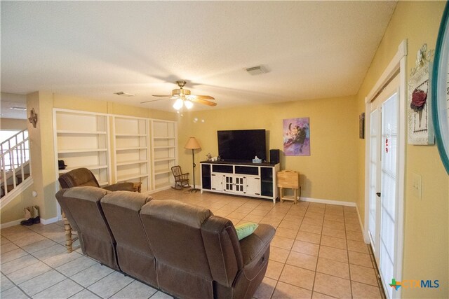 living room with a textured ceiling, a healthy amount of sunlight, ceiling fan, and light tile patterned floors