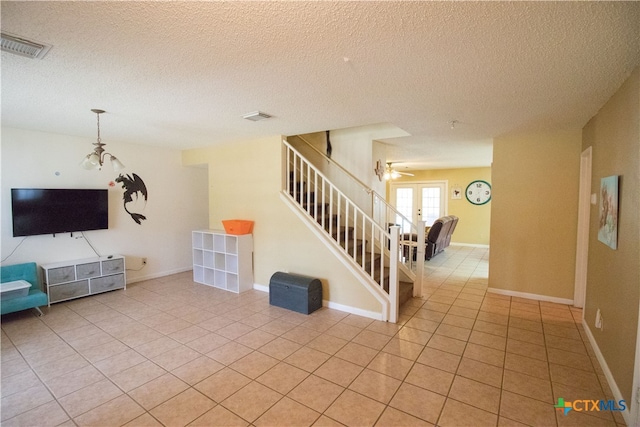 unfurnished living room with a textured ceiling and light tile patterned floors