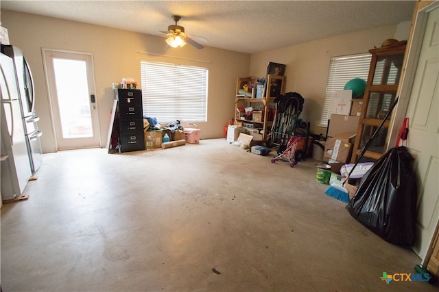 misc room featuring ceiling fan, concrete floors, and a textured ceiling