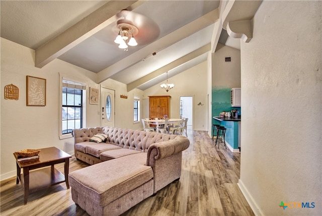 living area with beamed ceiling, baseboards, and wood finished floors