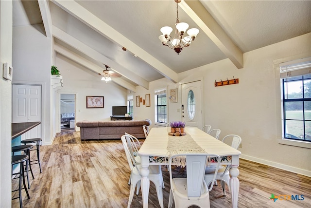 dining room with vaulted ceiling with beams, a healthy amount of sunlight, light wood-type flooring, and baseboards