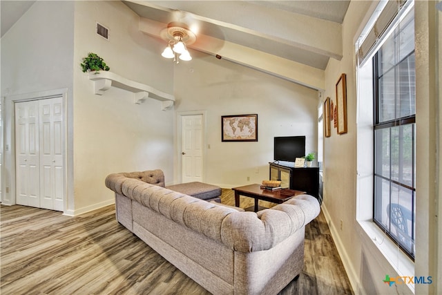 living room featuring a wealth of natural light, visible vents, baseboards, and wood finished floors