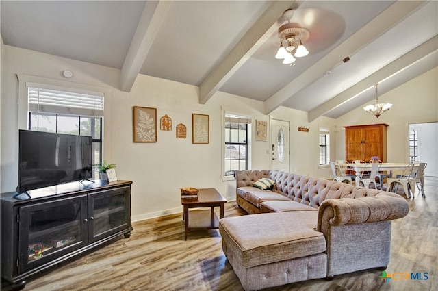 living area with vaulted ceiling with beams, wood finished floors, and baseboards