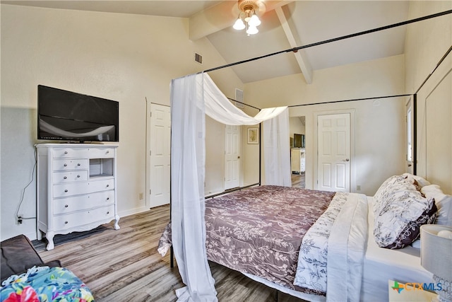 bedroom featuring visible vents, lofted ceiling with beams, and wood finished floors