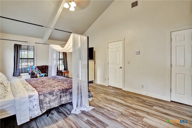 bedroom featuring high vaulted ceiling, baseboards, visible vents, and wood finished floors