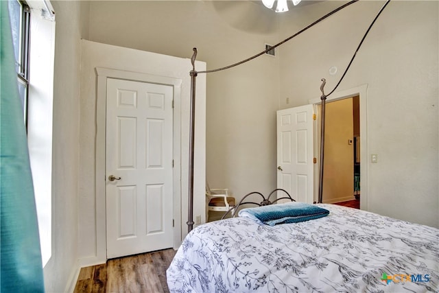 bedroom with multiple windows and wood finished floors