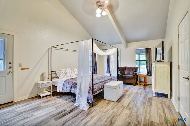 bedroom featuring ceiling fan, baseboards, wood finished floors, and beamed ceiling