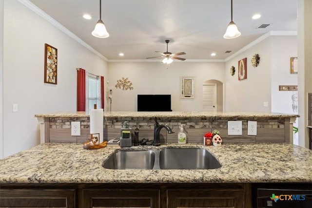 6407 Serpentine Dr, Killeen, TX 76542 - kitchen featuring crown molding, dark brown cabinetry, recessed lighting, light stone countertops, and open floor plan