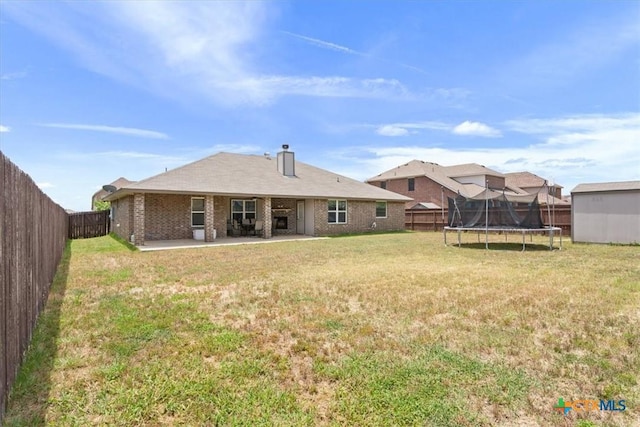 6407 Serpentine Dr, Killeen, TX 76542 - rear view of property with a trampoline, a patio area, a fenced backyard, brick siding, and a chimney