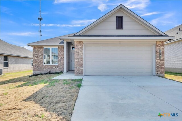 ranch-style home featuring a garage and a front lawn