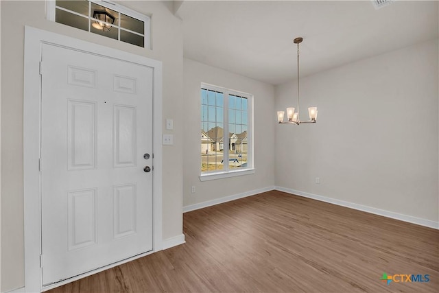 foyer entrance with a chandelier and hardwood / wood-style floors