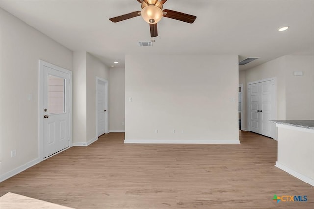 empty room with ceiling fan and light hardwood / wood-style floors