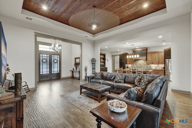 living room featuring wood ceiling, dark hardwood / wood-style flooring, and a raised ceiling