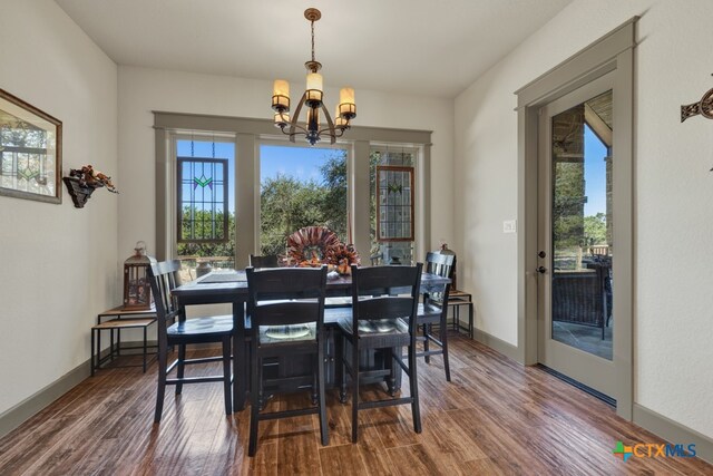 dining space featuring an inviting chandelier and dark wood-type flooring