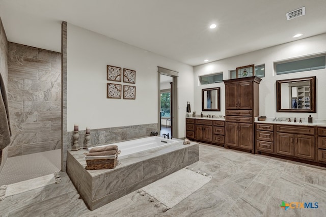 bathroom featuring vanity and plus walk in shower