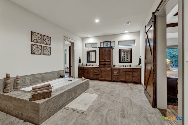 bathroom featuring vanity and a relaxing tiled tub