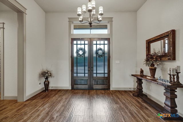 entryway featuring an inviting chandelier, wood-type flooring, and french doors