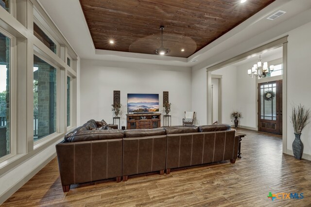 living room with wood-type flooring, wooden ceiling, and a tray ceiling