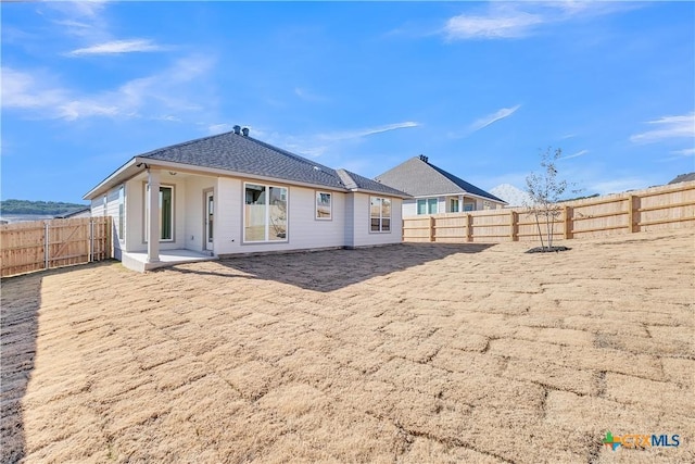 rear view of house with a fenced backyard