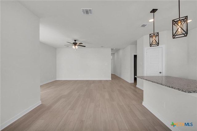 unfurnished living room with baseboards, visible vents, ceiling fan, and light wood finished floors