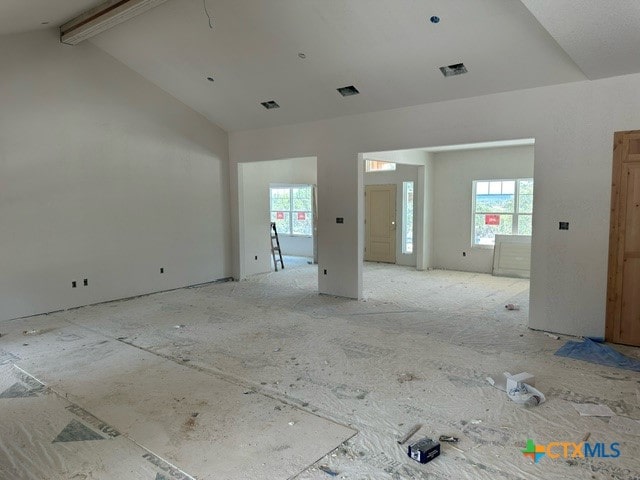 spare room featuring vaulted ceiling with beams