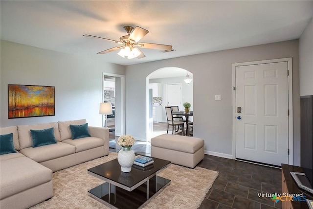 1504 Phyllis Dr, Copperas Cove, TX 76522 - living area featuring arched walkways, a ceiling fan, and dark stone finish floors