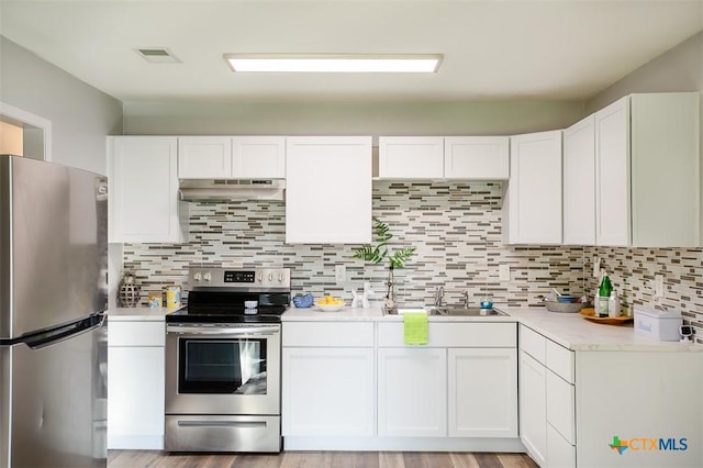 1504 Phyllis Dr, Copperas Cove, TX 76522 - kitchen featuring appliances with stainless steel finishes, under cabinet range hood, light countertops, white cabinets, and tasteful backsplash