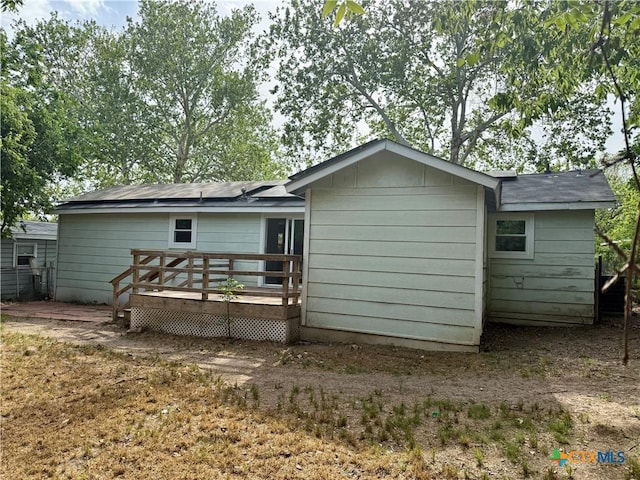 rear view of property featuring a wooden deck